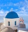 Blue-domed Greek church and belfry against volcano caldera on Santorini island, Cyclades, Greece