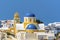 Blue domed, yellow churches in the town of Oia on the edge of the Caldera in Santorini
