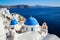 Blue domes and white walls of the church on the famous romantic island of Santorini.