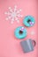 Blue Donuts with icing and coffe cup and snowflakes on pastel rose background. Sweet donuts.