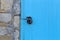 Blue door on stone wall locked with vintage locker