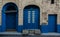 Blue doors on narrow alley sidewalks