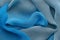 Blue draped silk scarf. Silk waves background