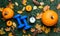 Blue dumbbells and autumn pumpkin wih alarm clock and leaves