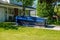 A blue dumpster in the driveway of a house in a residential neighborhood