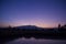 Blue dusk Mountains reflected in lake