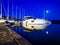 Blue dusk view on a quayside and moored sailboats, motorboats and yachts on a jetty