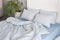 Blue ecologycal linen on bed in modern home interior. Daylight