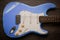 Blue electric guitar against brown wood background. Vintage age worn guitar