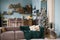 Blue and emerald Christmas interior. Living room with blue walls, dusty brown sofa and an emerald blanket