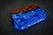 blue epoxy resin with nature burl BURMA PADAUK wood cube on black background