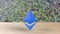 Blue Ethereum gold sign icon on wood table on leaves background. 3d render isolated illustration, cryptocurrency, crypto, business