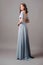 Blue evening dress with back slit. Beautiful female gown. Young adult elegant lady in high heels, studio shot. Bridesmaids dress.