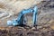 Blue excavator digging foundation