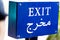 Blue exit sign in English and Arabic language written of white l