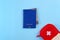 Blue external passport with airplane ticket inside and red travel first aid kit pouch on the bright blue background