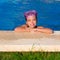 Blue eye kid girl on on blue pool poolside smiling