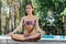 Blue-eyed modern woman sitting in lotus pose during yoga time