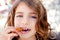 Blue eyes little girl eating fried crullers