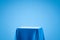 Blue fabric on podium shelf or empty studio display on light blue gradient background with art style. Blank stand for showing