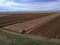 Blue Farm Tractor Plowing Large Farm Field