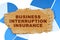 On the blue financial charts is a piece of cardboard that says - Business Interruption Insurance