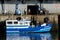 Blue Fishing boat alongside the wharf.