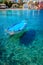 Blue fishing boat in the emerald azure rippled sea water bay in Assos village, Kefalonia island, Greece