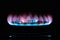 The blue flame of a cooker burner in the dark