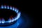 The blue flame of the gas burner of the kitchen stove in the dark. Place under the text