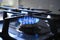 Blue flame from gas hob produce greenhouse gas emissions. Kitchen stove grate on a burner fuelled by combustible natural