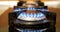 Blue flame of gas stove on black background. Kitchen burner turning on. Natural gas inflammation