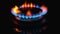 Blue flame of gas stove on black background. Kitchen burner turning on. Natural gas inflammation. chemical reaction. Staining the