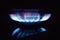 Blue flame of household gas on a kitchen stove on a black background