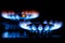 The blue flame of the two gas burner of the kitchen stove in the dark