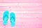 Blue flip flops on pink planks, summer concept background