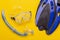 Blue flippers, snorkel and mask located on a yellow background, the concept of outdoor activities and diving