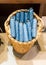 Blue foldable umbrellas in wicker basket on cement floor