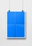 Blue folded poster hanging on a white wall with clips