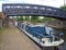 Blue footbridge crossing the calder and hebble navigation canal in brighouse west yorkshire with and old narrow boat moored