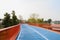 Blue footbridge with orange handrails over lake