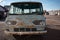 Blue ford falcon mini bus is parked in a desolate dirt lot