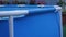 A blue frame swimming pool in the backyard of a country house. Camera movement from right to left