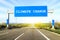 Blue freeway sign over the road on sunny day with words Climate