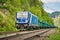 Blue freight train on the railway with a forest in the background during the daytime, Hirschmuhle