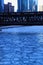 Blue and frigid winter morning in Chicago while el train passes over Chicago River and buildings reflect cityscape.