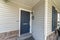 Blue front door of a house with white welcome calligraphy at the front