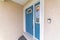 Blue front door with ornate glass panes and doorbell camera