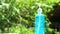 Blue gel bottle and blur green tree in garden