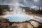 Blue geyser basin with smoke boiling in dry environment